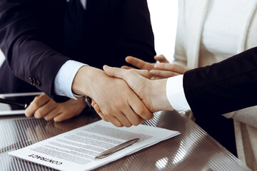 Business people shaking hands after contract signing in modern office. Teamwork, partnership and handshake concept