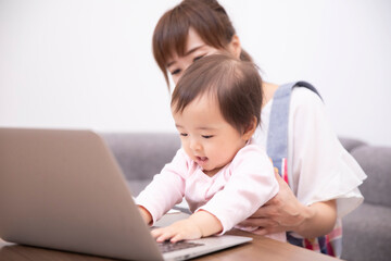 パソコンを使う主婦と赤ちゃん
