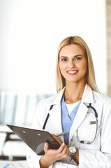 Woman-doctor controls medication history record and medical exam results. at black clipboard. Medicine concept