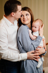 Mom and Dad hold in their arms the infant. 