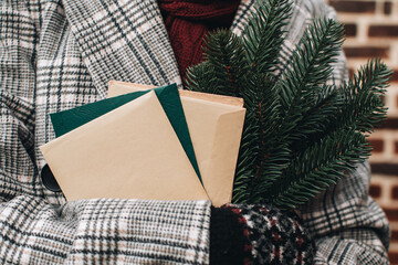 Naklejka premium Girl carries Christmas letters and sprigs of fir. Cozy Christmas winter atmosphere. Scandinavian hygge concept.