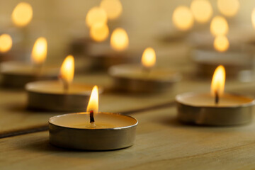 Burning candles on a wooden background, shot with shallow depth of field.