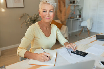 Accounting, bookeeping and finances. Portrait of stylish mature female economist working from home,...