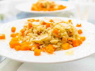 Risotto with carrot and parmesan on white background