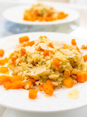 Risotto with carrot and parmesan on white background