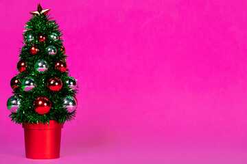 Artificial Christmas tree and details on it. Purple background.