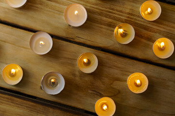 Top view of many burning candles on a wooden , shot with shallow depth of field.