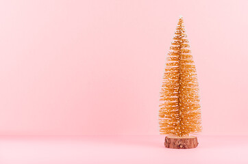 New Year background with golden sparkle christmas tree on soft light pink backdrop.