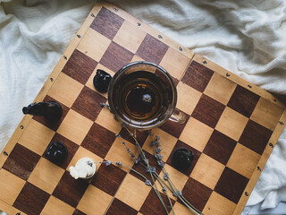 a cap of tea, flower  and chessboard  