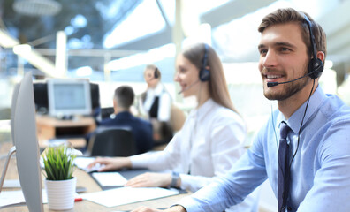 Naklejka premium Line of call centre employees working on computers