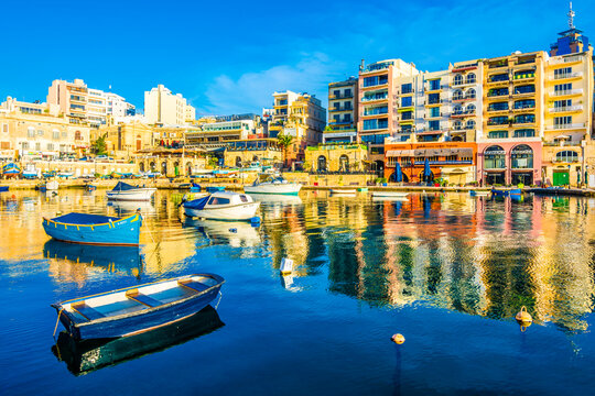 Small fishing boats moored in St Julians and Spinola bay on a sunny day  in St Julians, Malta.