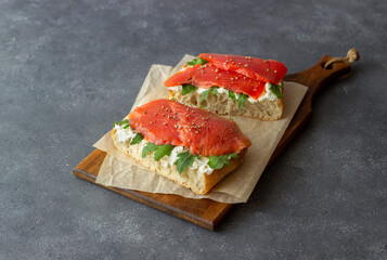 Open sandwiches with salmon, arugula and white cheese. Healthy eating.