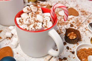sweet food top view background for merry christmas or new year holiday decoration - chocolate candies, tangerines, cookies, marshmallow and cocoa latte on white wood