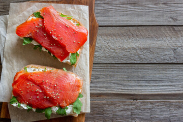 Open sandwiches with salmon, arugula and white cheese. Healthy eating.