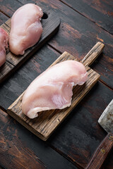 Chicken uncooked meat with butcher knife on dark wooden background