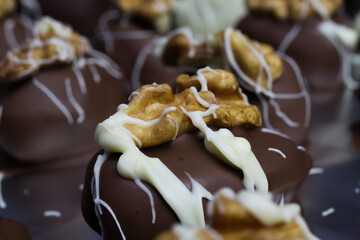 Close up of homemade black and white christmas chocolate pralines filled with walnuts, marzipan and figs