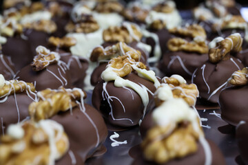 Close up of homemade black and white christmas chocolate pralines filled with walnuts, marzipan and...