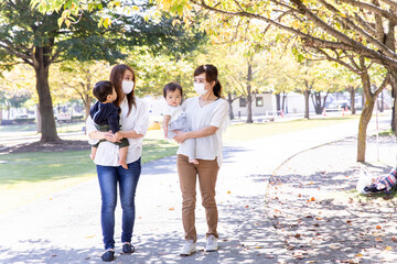 Fototapeta premium 公園で遊ぶマスク姿のママ友と子供 