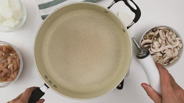 Pasta with chicken and mushrooms recipe. Chef pouring coking oil into a frying pan
