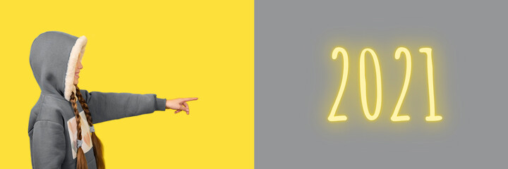 Teen beautiful girl pointing her finger on 2021. Banner with copy space.