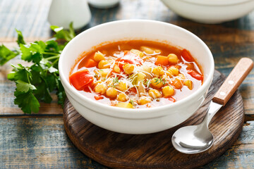 Vegetables soup bowl. Tuscan tomato chickpea soup with various vegetables, thyme and parmesan cheese.