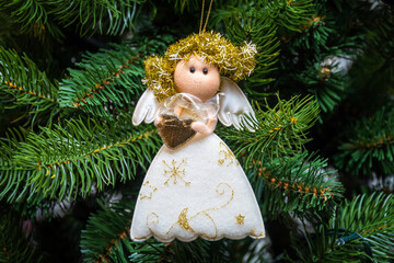 Christmas tree decoration white angel with shiny wings and Golden hair.