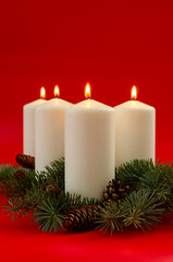 White christmas candles on red background, Advent. 4 burning candles.