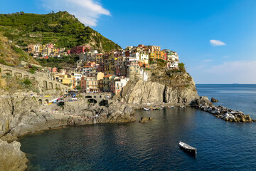 Fototapeta na wymiar Commune of Manarola, with its colorful houses, on the stone cliffs by the sea, La Spezia Province, one of the towns that make up the famous Cinque Terre, Italy