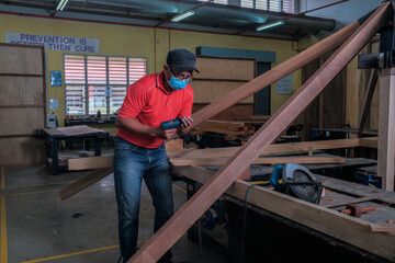 Fototapeta na wymiar The carpenter using cordless drill for installing roof rafters on a new gazebo construction project