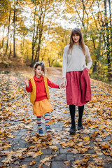 mom with emotional and hyperactive daughter are walking in the park