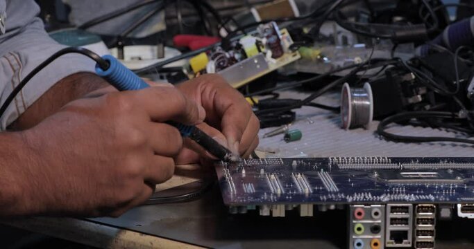 Technicians are using a soldering iron for repairing electronic of the computer circuit board concept technology of computer circuit hardware