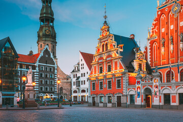 Riga, Latvia. Scenic Town Hall Square With St. Peter's Church, Schwabe House, House Of Blackheads. Popular Showplace With Famous Landmarks On It In Evening Illumination.