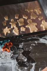 Making gingerbread man, ginger cookie dough. The concept of a feast in the house, a family dinner. New Year traditions concept and cooking process. Cookies on dark brown wooden table. 