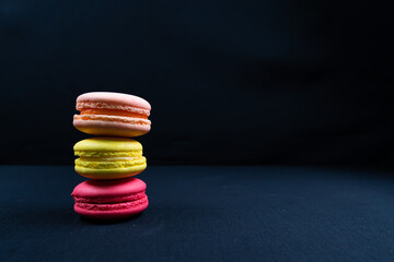 Colourful stack of macaroons isolated on plain black background, Copyspace