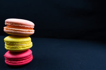 Colourful stack of macaroons isolated on plain black background. Copyspace