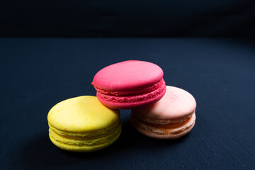 Colourful stack of macaroons isolated on plain black background. Copyspace