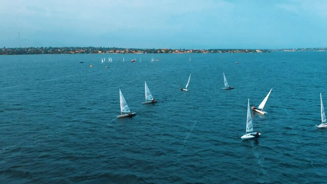 Top view of floating sailing yachts. View from above on the sailing yacht on the river. Competition of sailing boats. Beautiful waterscape.