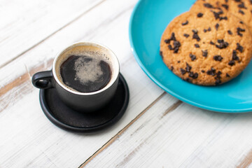 A cup of coffee and cookies with chocolate