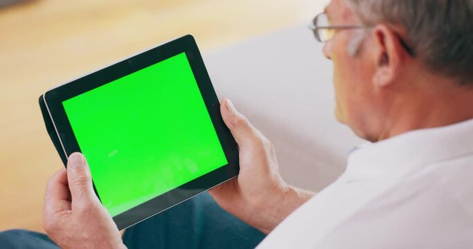 A senior takes a video call on a tablet computer, which features a green screen.