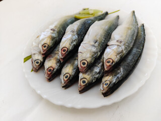 Close up view of fresh curry cut ready to cook Indian Mackerel Fish decorated with Herbs .