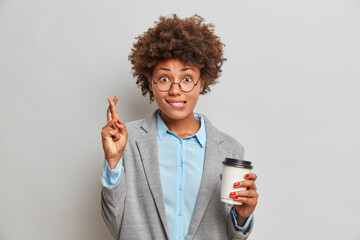 Superstitious dark skinned woman manager crosses fingers for good luck believes in something good...