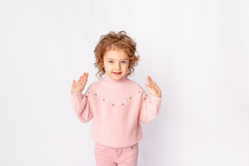 little baby girl in pink winter clothes on white background rejoices, space for text