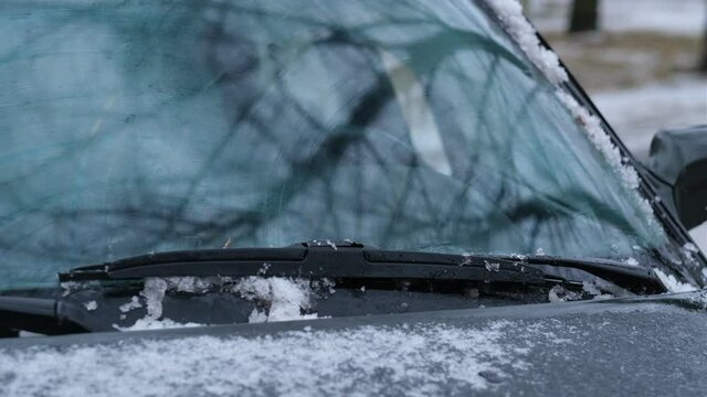 closeup element of car cleaning windshield wipers from snow and ice