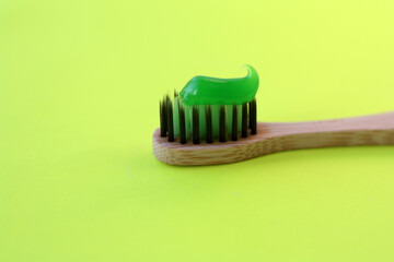 Organic bamboo toothbrush. Green toothpaste. Yellow background. Ecological, natural, carbon brush, ...