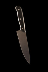 A large kitchen knife with a black handle on a dark background. Knife with a wide sharp blade. Not scratched steel surface of the knife blade.