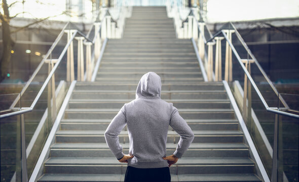 Man in hoodie preparing for stair run.