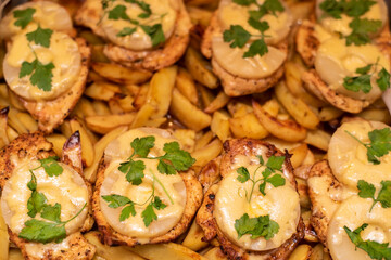 Chicken fillets with pineapple and cheese are baked together with potatoes, not diet but delicious food cooked at home by a skilled woman
