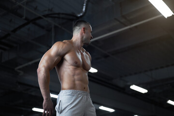 Fototapeta na wymiar Muscular athletic bodybuilder fitness model standing gym
