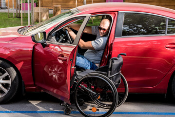 Young handicapped man on driver's seat of his car