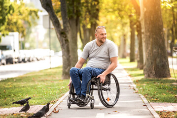 Handicapped man in wheelchair walk at the park alley